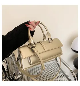 Detailansicht einer champagnergoldenen Baguette-Tasche aus metallischem Kunstleder mit Gurt
