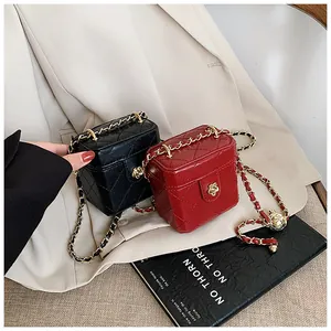 Détail de mini sacs boîte matelassés noir et rouge avec boucles dorées en forme de fleur