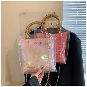 Detail of transparent PVC bag with bamboo handle, gold chain and Frida Kahlo pouch