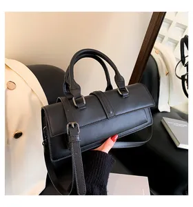 Nahaufnahme der schwarzen matten Leder Baguette Tasche mit Doppelgriffen und Schnallen-Detail