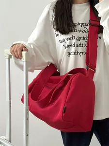 Detail of red canvas cylinder gym bag with wide adjustable shoulder strap and double handles