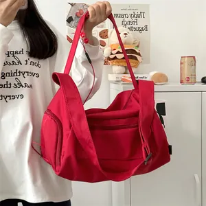 Close-up of a large capacity red travel bag with adjustable strap and multiple pockets