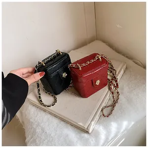 Détail de mini sacs boîte matelassés noir et rouge foncé avec boucle fleur dorée