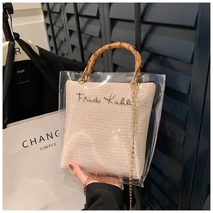 Detail of transparent PVC handbag with bamboo handle, woven inner pouch, and gold chain