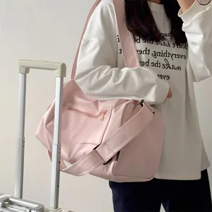 Detailed side view of the pale pink large capacity gym bag with adjustable shoulder strap
