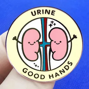 Funny cartoon kidney enamel pin with URINE GOOD HANDS slogan on yellow background