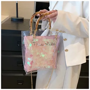 Detail of transparent PVC bag with bamboo handle and pink sequin Frida Kahlo pouch