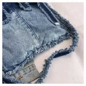Detail of light blue denim tote with heavy distressing and frayed fringe edges