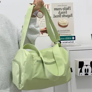 Detail of mint green sports gym bag showing wide shoulder strap and side zipper pocket