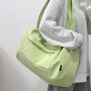 Detail view of large mint green nylon fitness bag with zipper pocket and shoulder strap