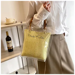 Detail view of transparent bag with bamboo handles and yellow Frida Kahlo embroidered pouch