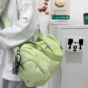 Detail of mint green yoga duffel bag with checkerboard charm shown in lifestyle setting