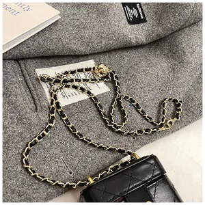 Détail du mini sac boîte en cuir matelassé noir avec boucle dorée et bandoulière chaîne