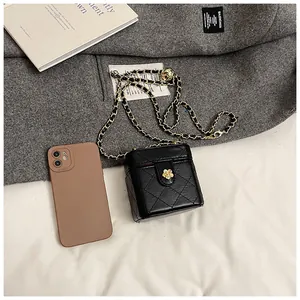 Mini sac matelassé noir avec boucle rose dorée et smartphone pour comparer la taille