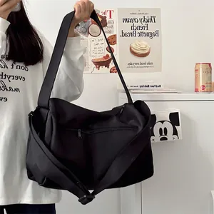 Detailed view of black gym bag with adjustable shoulder strap and external zipper pocket