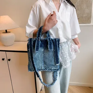 Frayed denim tote bag with gradient wash and shoulder strap for casual styling