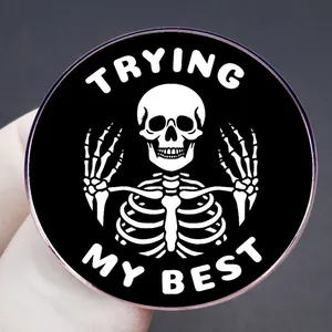 Inspirational skeleton enamel pin with Trying My Best text in black and white finish