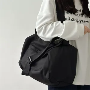 Detail of a large black nylon fitness bag with adjustable strap and dual zipper pockets