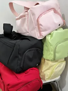 Pile of large capacity nylon gym bags shown in pink, black, green, yellow, and red colors