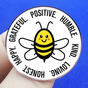Badge en émail avec abeille et mots de motivation positifs sur fond bleu texturé