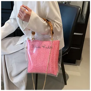 Detail showing transparent bamboo handle handbag with pink inner bag and gold chain strap
