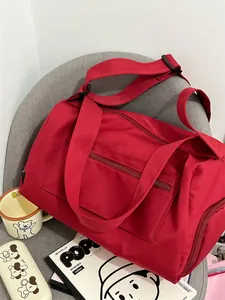 Detailed macro view of red nylon fitness bag with adjustable shoulder strap and zippers