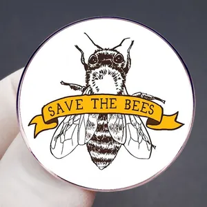 Save The Bees enamel pin badge featuring a yellow ribbon and detailed bee illustration