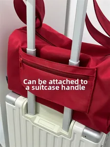Detail of red travel bag featuring a trolley sleeve for securing to luggage handles