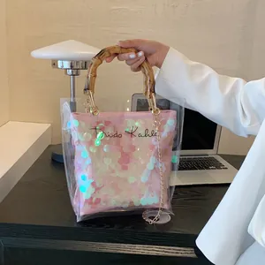 Clear tote bag with pink sequined inner pouch and bamboo handles featuring Frida Kahlo text