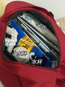 Deep red pillow bag interior showing large capacity for sweatshirt books and water bottle