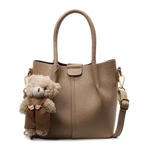 Chic light brown litchi leather tote bag with cute bear charm and gold-tone hardware