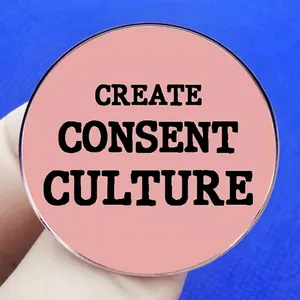 Pink Create Consent Culture feminist brooch with bold black lettering on deep blue background