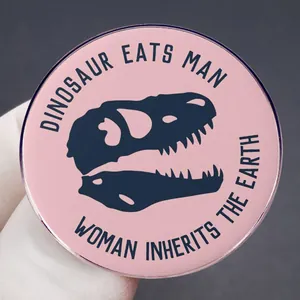 Pink enamel dinosaur skull brooch with Dinosaur Eats Man Woman Inherits The Earth text