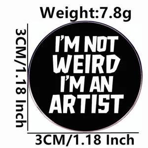 3cm round black metal brooch with I am not weird I am an artist text and size labels