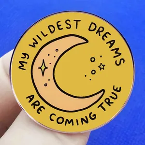 Yellow badge with moon and My Wildest Dreams Are Coming True slogan on blue background