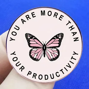 Pink butterfly enamel pin with 'You Are More Than Your Productivity' text on blue background