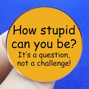 Humorous yellow round enamel pin with sarcastic text It's a question not a challenge