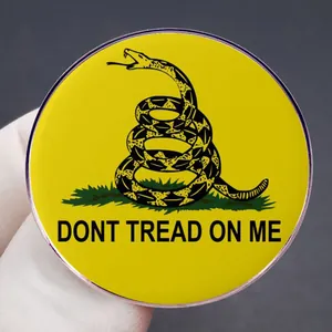 Round yellow Gadsden flag metal pin badge featuring a coiled rattlesnake and text