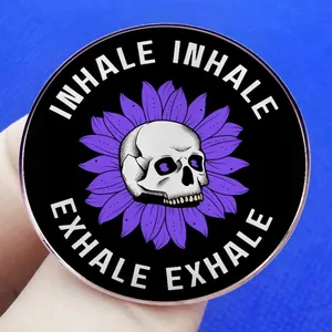 Badge rond en métal avec crâne et pétales de fleurs mauves avec texte Inhale Exhale