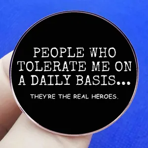 Broche ronde en émail noir avec texte: People who tolerate me are the real heroes