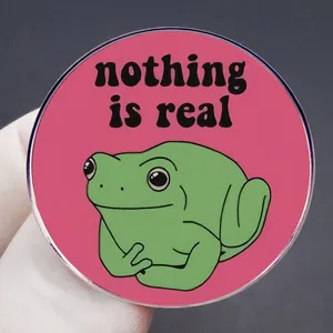 Funny green frog badge with Nothing Is Real text on a bright pink background