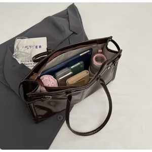 Detail shot of the spacious interior of this brown vintage tote bag holding daily essentials