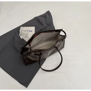 Top view of large dark brown tote bag interior featuring zipper pocket and main compartment