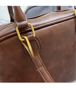 Macro shot of durable golden metal hooks and dark brown vintage leather bag details