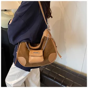 Detail of vintage suede and leather patchwork crossbody bag with mini pouch and silver chain