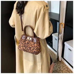 Detailed close-up of leopard print texture and gold twist lock on the crossbody bag