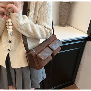Detail view of retro brown faux suede baguette bag with dual front flap pockets