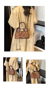 Detail of leopard print crossbody bag with gold twist lock and brown leather handle