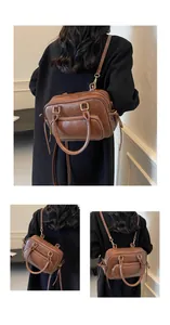 Detail view of brown vintage PU leather Boston bag with gold hardware and side pocket
