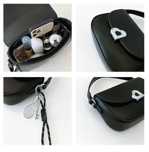 Detail view of black PU leather bag with silver heart buckle and interior storage capacity